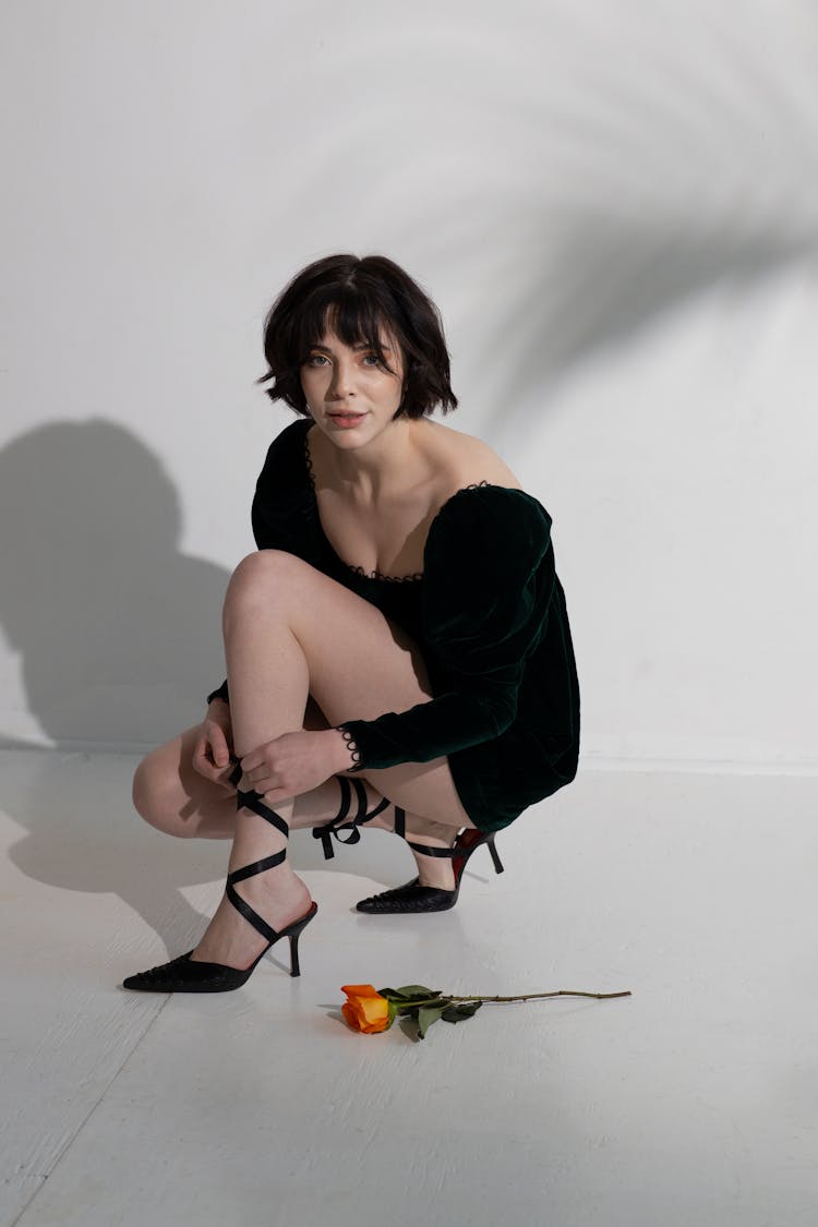 Woman Tying Heels On Floor Near Flower