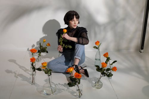 Lady near vases with flowers on floor