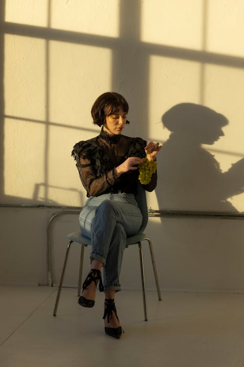 A Woman in Black Long Sleeve Shirt Sitting on the Chair