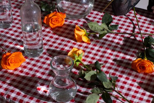 Free From above of fresh roses with orange delicate petals and green stems on table Stock Photo