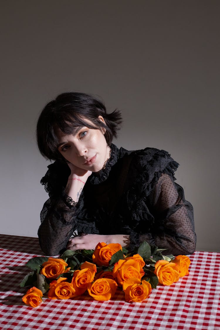 Gothic Elegant Woman At Table With Bouquet Of Roses