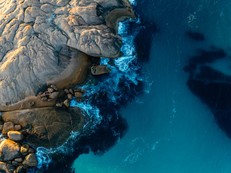 Aerial View Of Ocean Waves Crashing On A Rock Formation