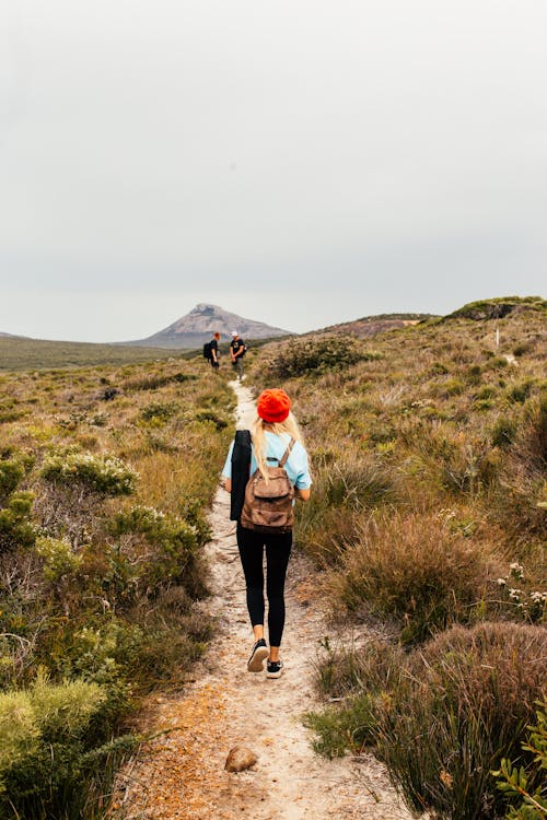 A Woman Wearing Red Knit Cap Walking on the Trail