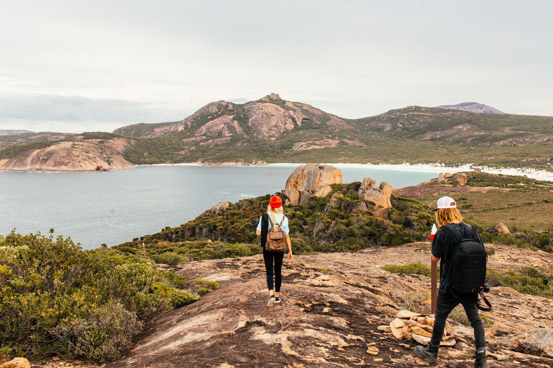 Two hikers explore a stunning coastal landscape, enjoying the natural beauty and adventure.