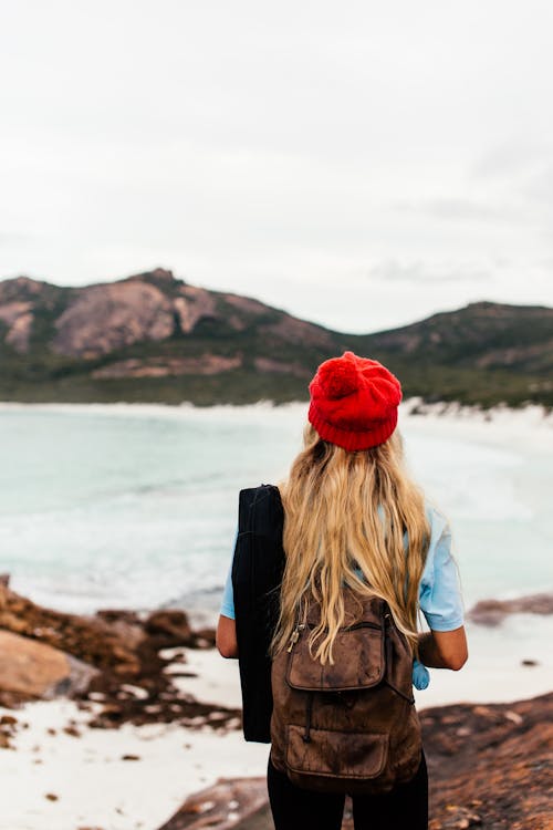 A Person with red Knit Cap and Brown Backpack