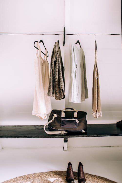 Clothes Hanging on a Rack and Boots Standing on the Floor 