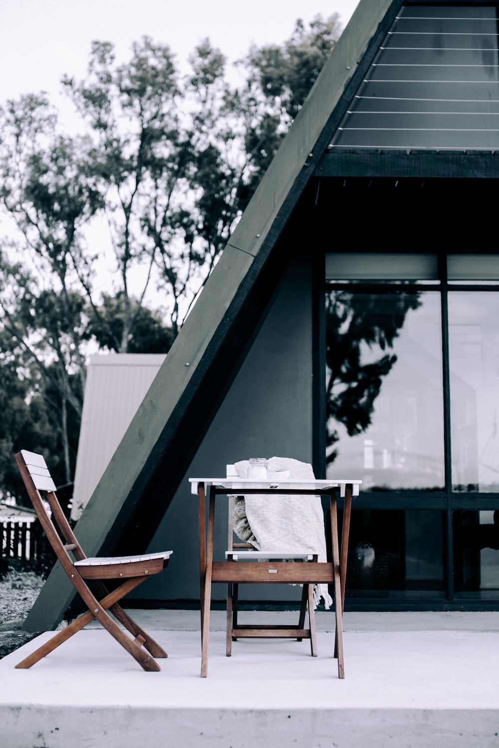 A-frame timber cabin terrace with wooden chairs