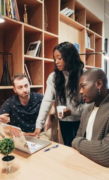 A diverse group of colleagues engaged in a collaborative discussion within a modern office setting.