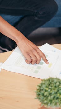 Close-up of a person pointing at a business document in an office setting.