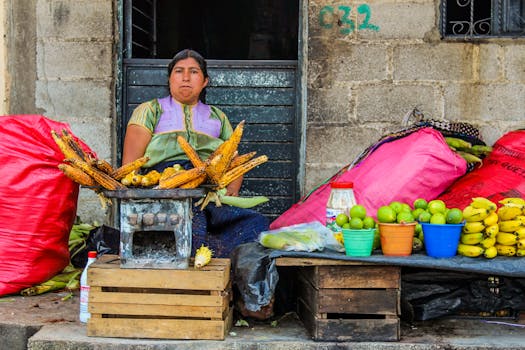 A woman selling grilled corn and fruit at a vibrant street market in San Cristobal de las Casas, Mexico.