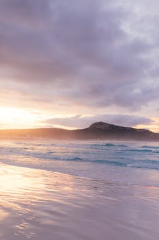Breathtaking sunrise over calm ocean waves at a serene beach, perfect for nature enthusiasts.