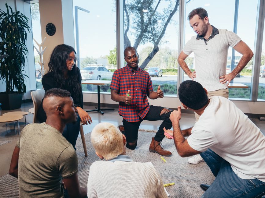 A diverse team engaging in a lively discussion in a modern office setting.