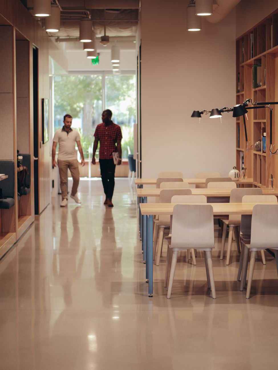 Two colleagues walking through a modern office space, discussing ideas and projects.