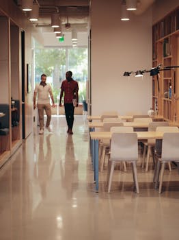 Two colleagues walking through a modern office space, discussing ideas and projects.