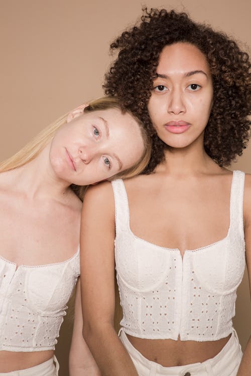 Calm multiracial women in trendy white clothes