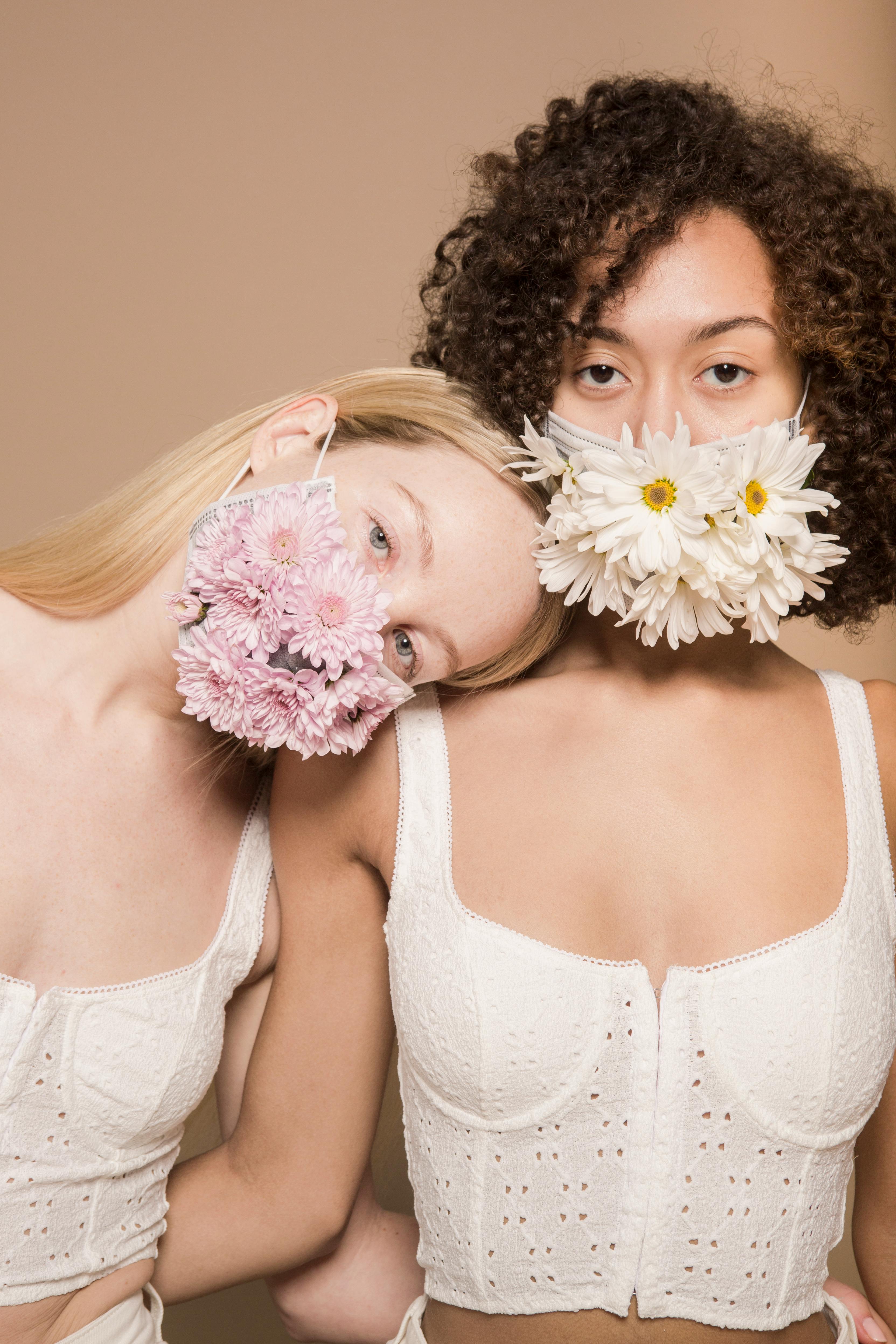 multiracial women wearing colorful flower masks