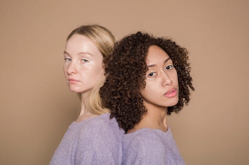 Calm diverse women with colorful makeup