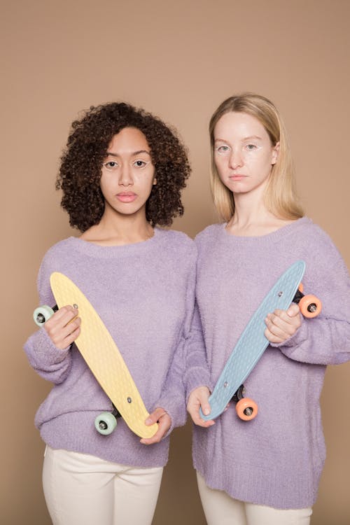 Multiethnic women with pastel colored skateboards