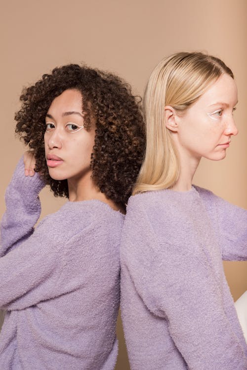 Multiracial friends leaning backs in studio