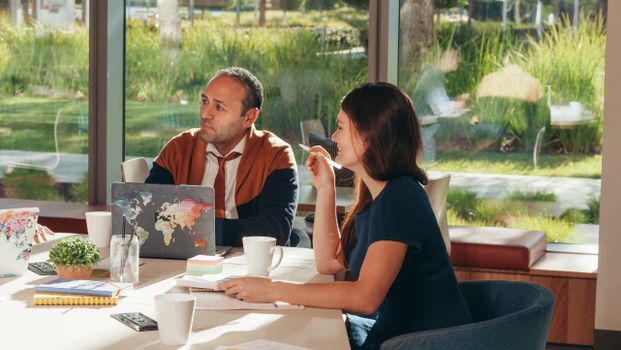 Colleagues discussing business strategy in modern office with natural light.