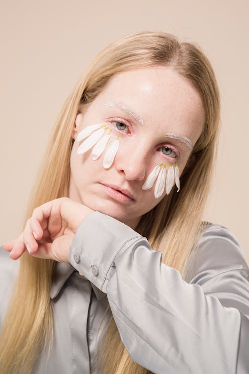 Trendy woman with organic petals on face