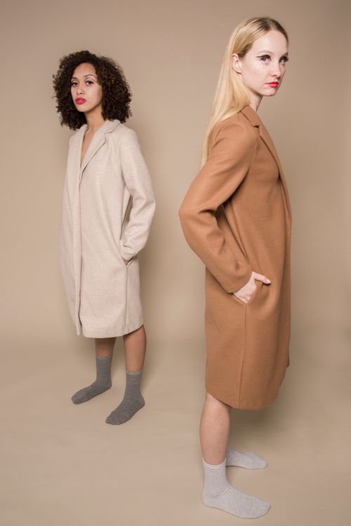 Free Full body of diverse friends with dark short and fait long hair in formal coats on beige background Stock Photo