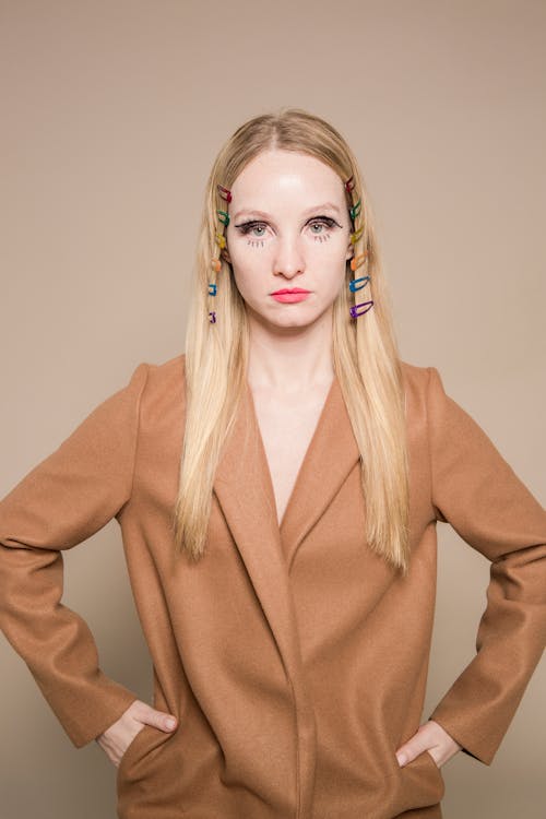 Trendy woman with hair clips on head in brown coat