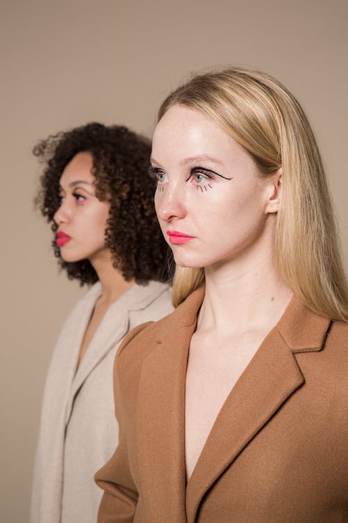 Stylish models looking away against beige background
