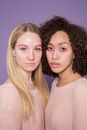 Unhappy multiracial girlfriends with colorful makeup in studio