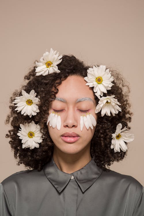 Gentle ethnic woman with chamomile flowers in hair