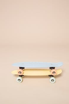 Two colorful skateboards stacked on a beige background, showcasing minimal and modern design.