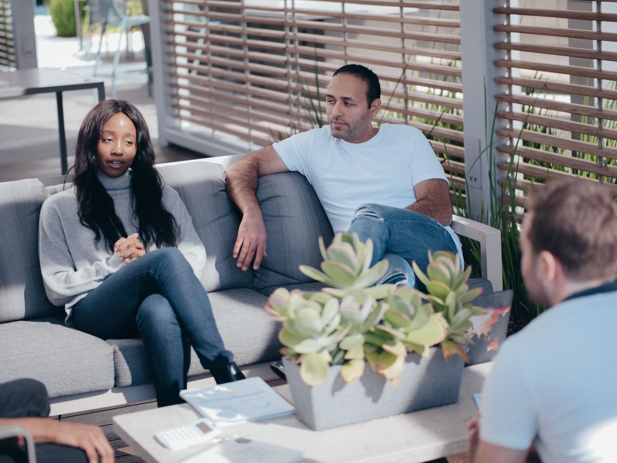 Colleagues in an informal outdoor discussion on a sunny day