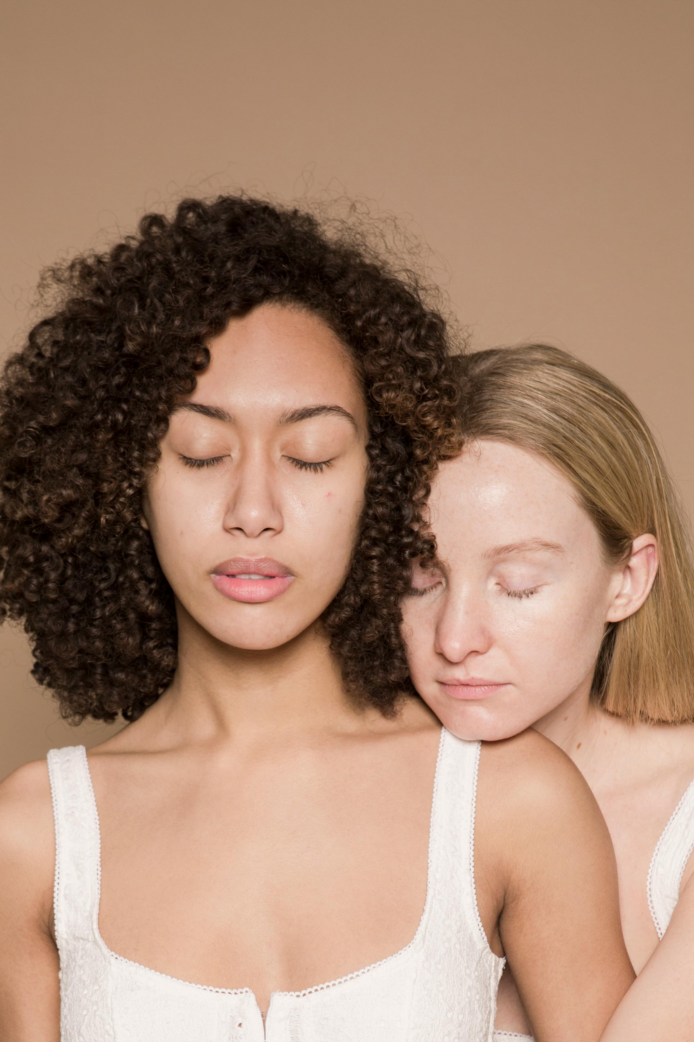 calm multiracial female models with closed eyes im beige studio