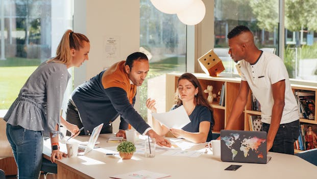 A diverse group of colleagues engaging in a collaborative meeting in a modern office space filled with light.
