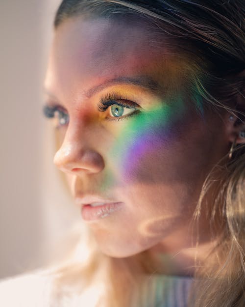 Side view of young pensive female with long blond hair and makeup looking away