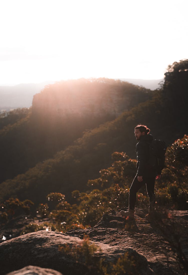 Traveling Man Standing On Green Slope Of Hill