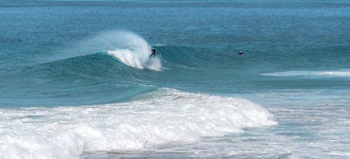 Stormy sea with surfers on sunny day