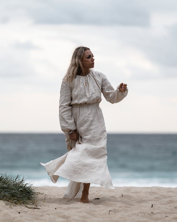 Thoughtful woman walking on beach near sea