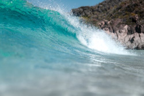 Wavy blue sea near rocky formations on coast