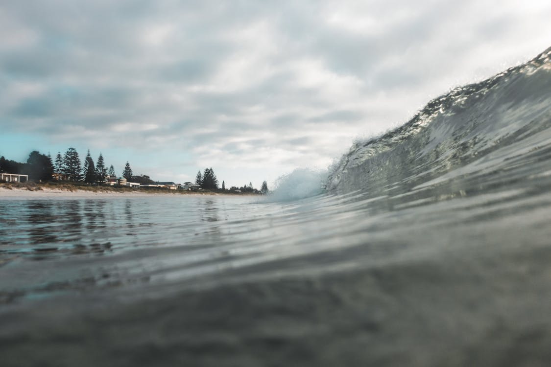 Wavy ocean near coast under cloudy sky