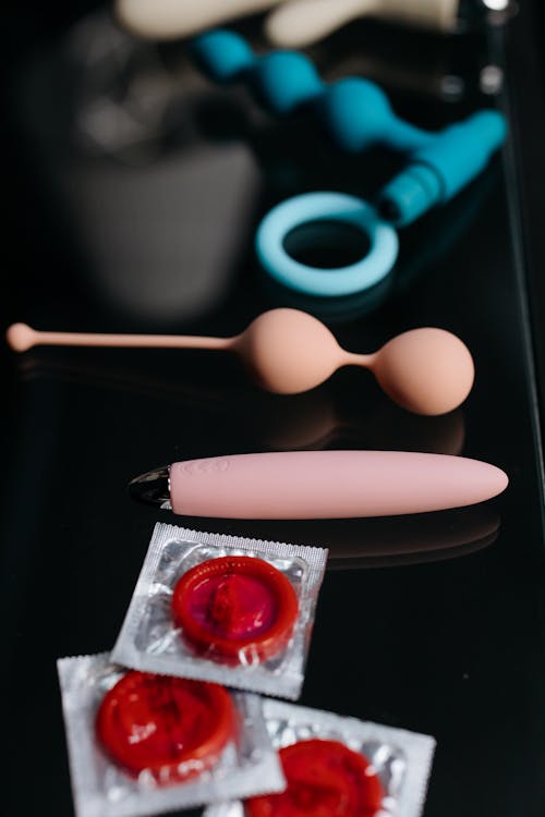 Free Condoms and Sex Toys on a Black Surface Stock Photo
