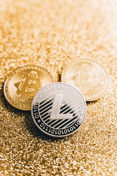 Close-up of Bitcoin and Litecoin coins on a shiny gold surface, symbolizing digital currency and investment.