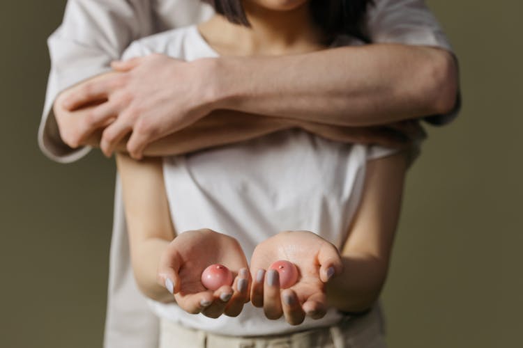 A Man Holding A Child That Is Holding A Fruit