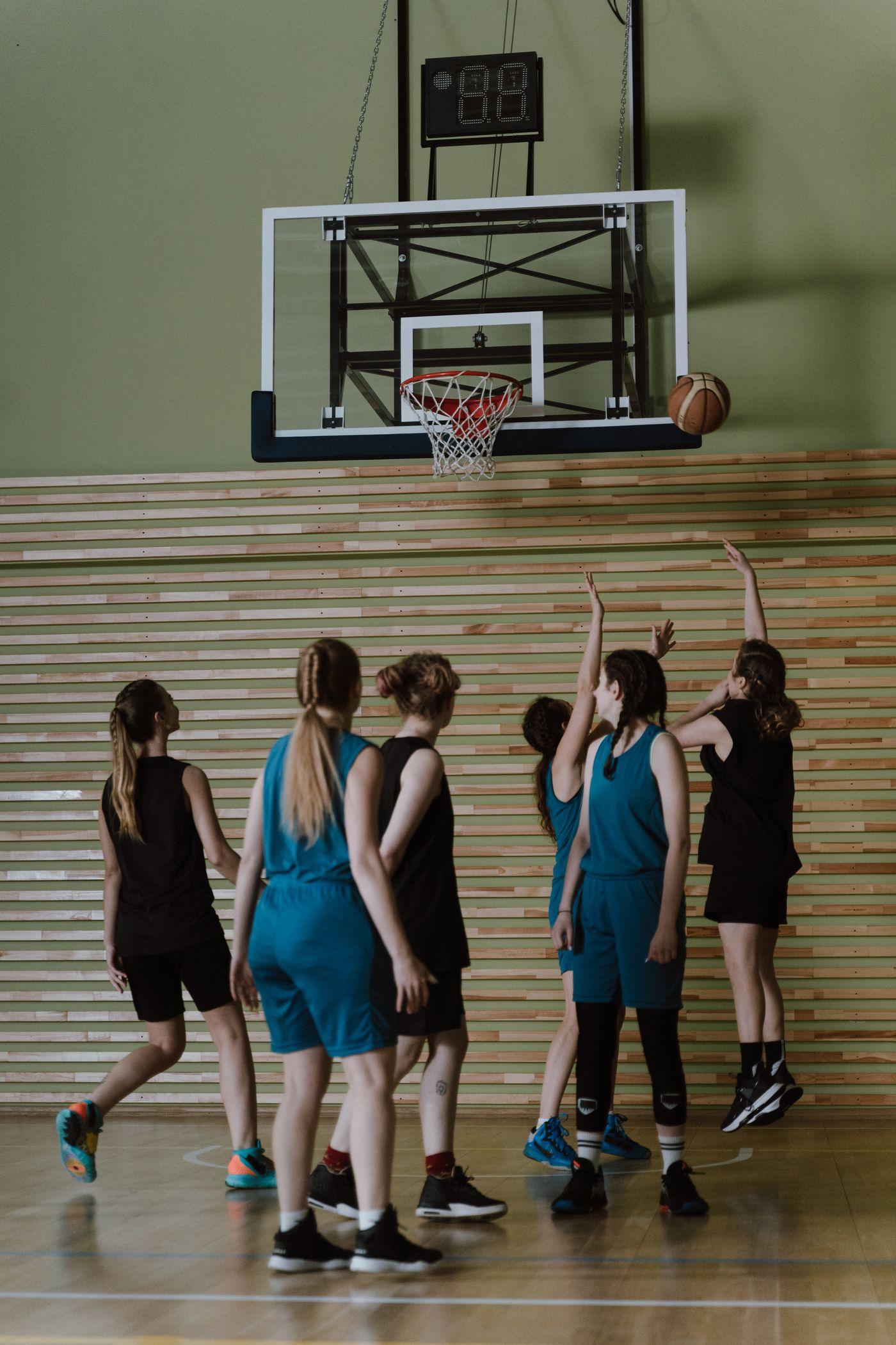 A group of players shooting at the hoop during practice