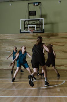 Dynamic indoor basketball game featuring female players in action on the court.