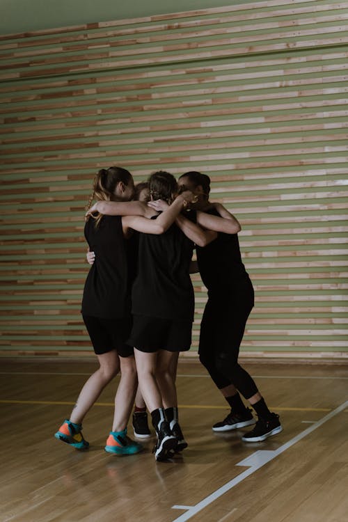 Players in Black Uniform Embracing Each Other