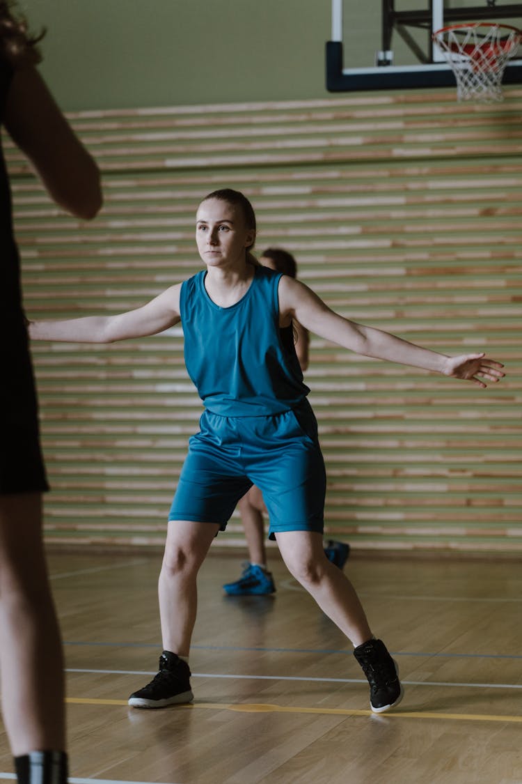 A Woman In Blue Uniform Blocking A Person