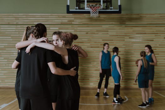 A group of young women basketball players huddle for motivation before a game.