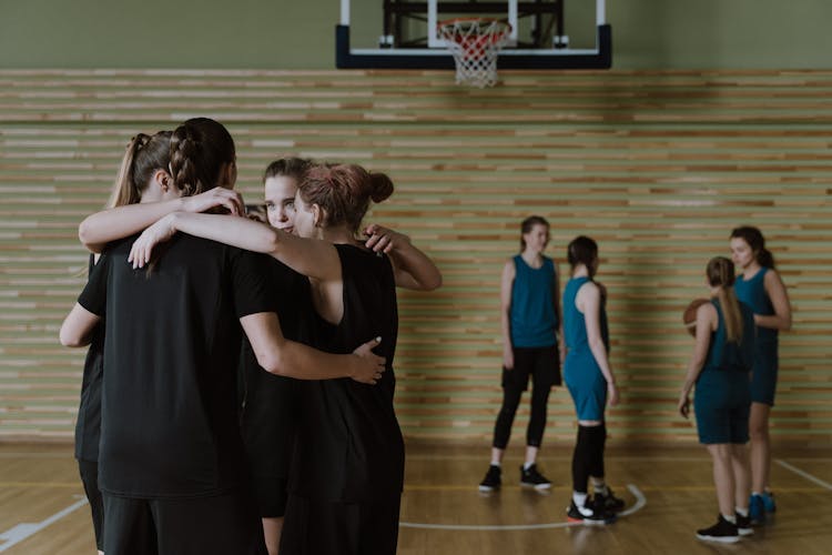 A Group Of Women In Black Group Hugging