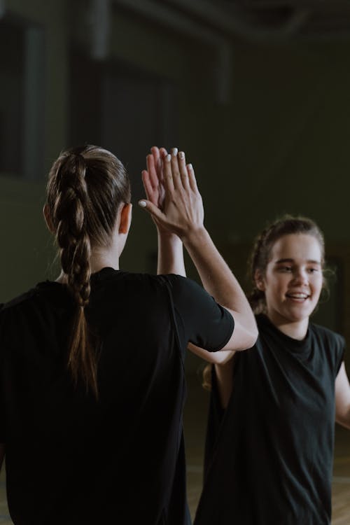 Free A Young Woman and a Person Doing a High Five Stock Photo